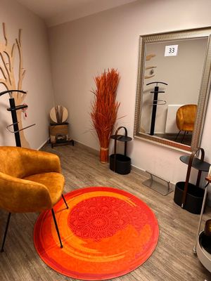 a chair and a mirror in a room with wood flooring