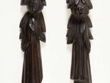 pair of carved wood wall hangings of a man and a woman
