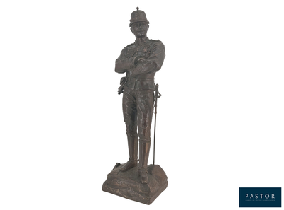 une statue représentant un homme coiffé d'un chapeau et muni d'une canne