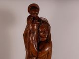 wooden statue of a woman holding a child in her arms