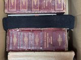 Plusieurs livres sont empilés les uns sur les autres dans une boîte en carton.