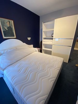a white bed in a room with a blue wall