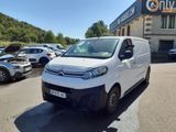 la camionnette blanche est garée devant un bâtiment dans un parking