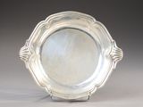 an antique silver plate on a stand on a gray background