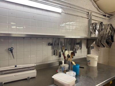 un plan de travail de cuisine avec tout un tas d'ustensiles accrochés au mur