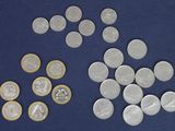a lot of coins that are on a blue surface
