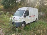 a van that is parked in the grass by a fence