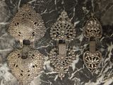 plusieurs bijoux anciens en argent posés sur une surface en marbre