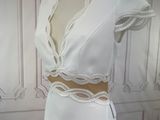 a white dress on a mannequin stand in front of a wall