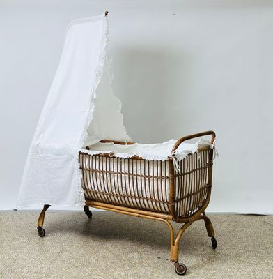 Berceau en rotin orné d'un ciel de lit en coton blanc (roule…
