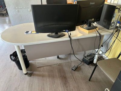 two computer monitors sitting on a desk in a room
