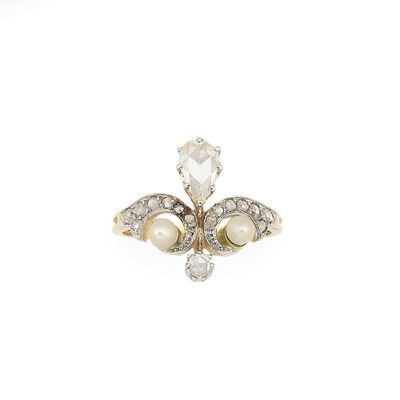 un gros plan d'une bague sertie d'un diamant et d'une perle sur fond blanc