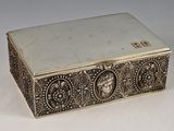 une boîte ancienne en argent posée sur une surface blanche, sur laquelle figure un numéro