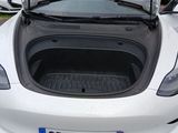 a white car with its trunk open in a parking lot