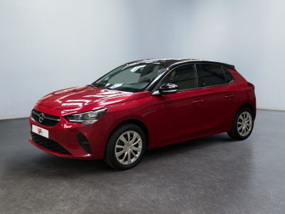Une voiture rouge est garée dans une pièce aux murs blancs