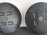 two metal plates with holes on them on a table