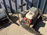 a small lawn mower sitting on the ground next to a tank