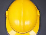 a yellow hard hat on a black surface