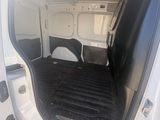 the back of a white van with the door open and a black mat on the floor