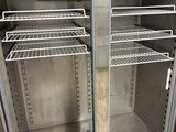 stainless steel double door freezer with shelves in a commercial kitchen