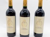trois bouteilles de vin sont alignées sur une surface blanche