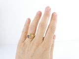 a woman ' s hand with a gold ring on it