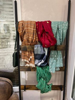 a ladder with clothes hanging on it in a living room