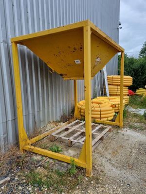 un tas de tuyaux jaunes posés sur une palette à côté d'un bâtiment