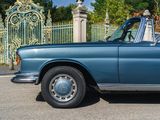 a blue car that is parked in front of a gate