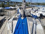 a sailboat with a blue cover parked at a dock