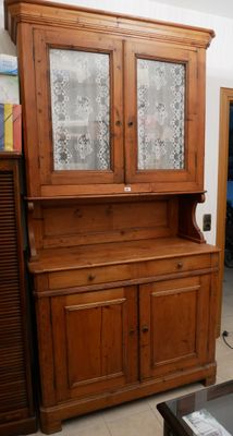 une armoire en bois à deux portes, dont l'une est vitrée