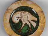 une assiette sur laquelle est représenté un oiseau, sur un fond blanc
