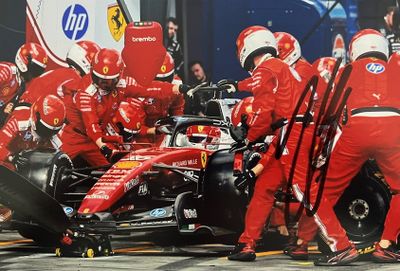 des mécaniciens Ferrari travaillant sur une voiture dans les stands
