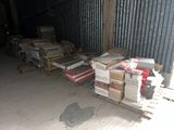 several stacks of books are stacked on pallets in a warehouse