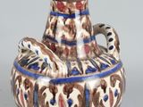 a vase with a bird on it sitting on a table