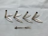 four silver metal spikes and a screw on a white sheet