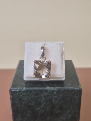 sterling silver square pendant with a star on top of a marble block