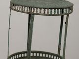 a green metal lantern on a table with a white wall