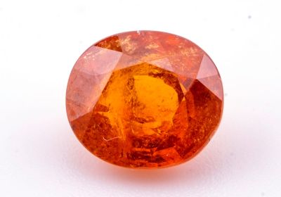 un gros plan d'un saphir orange sur une surface blanche