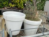 two white buckets sitting on top of a metal rack