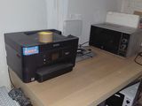 a printer sitting on top of a desk next to a microwave