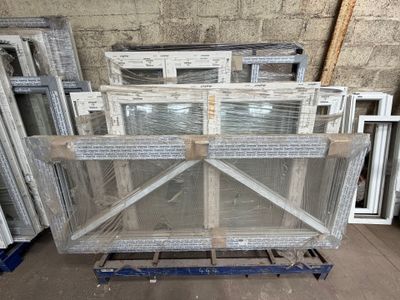 Plusieurs morceaux de verre sont empilés sur une palette dans un entrepôt