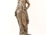 bronze statue of a woman holding a flower on a marble base