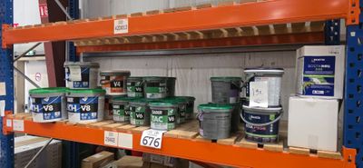 de nombreux pots de peinture sur les étagères de l'entrepôt