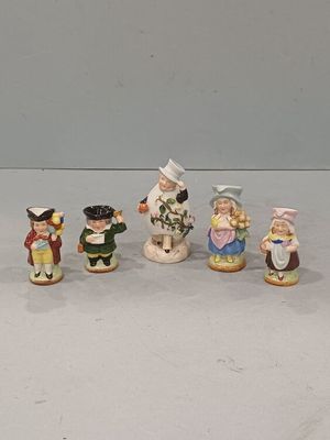 cinq figurines représentant des enfants vêtus de costumes différents