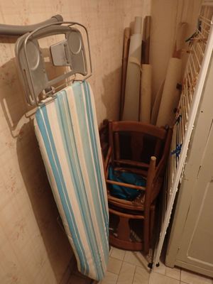 une table à repasser et une chaise dans une petite pièce