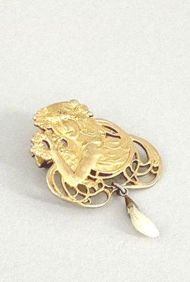une broche en or sur laquelle est représentée une femme