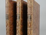 two old books are stacked on top of each other on a table