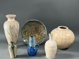 four vases and a bowl sitting on a table