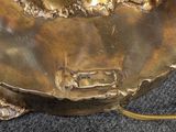 a gold statue of a turtle on a black surface